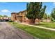 Well-maintained brick apartment building featuring mature landscaping and a tidy lawn on a clear, sunny day at 1535 Hudson St # 1, Denver, CO 80220