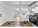 Compact kitchen featuring white cabinetry, stainless steel appliances, and unique tile floors at 1535 Hudson St # 1, Denver, CO 80220