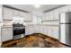Updated kitchen with white cabinets, stainless steel appliances, and unique tile floors at 1535 Hudson St # 1, Denver, CO 80220