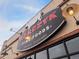 The Marczyk Fine Foods shop features prominent signage and exterior lighting on a brick building in Denver, Colorado at 1535 Hudson St # 1, Denver, CO 80220