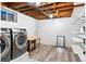 Basement laundry room with new front load washer, dryer, and storage space with wood look floors at 4100 Shaw Blvd, Westminster, CO 80031