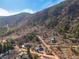 Aerial view of the property on a hillside surrounded by lush trees and landscape at 402 Roosevelt St, Palmer Lake, CO 80133