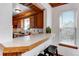 Charming breakfast bar with wooden trim accents looks into the connected kitchen space with natural light from windows at 402 Roosevelt St, Palmer Lake, CO 80133