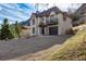 Attractive two-story home featuring cream siding with red trim, situated on a gently sloping, well-maintained lawn at 402 Roosevelt St, Palmer Lake, CO 80133