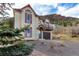 Charming two-story home featuring cream siding with attractive red trim, with a well-maintained gravel front yard at 402 Roosevelt St, Palmer Lake, CO 80133
