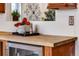 Kitchen butcher block countertop and cabinets with an under-counter stainless wine cooler at 402 Roosevelt St, Palmer Lake, CO 80133