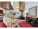 Spacious living room featuring a fireplace, tall ceilings with unique copper colored tiles, and large windows at 402 Roosevelt St, Palmer Lake, CO 80133
