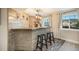 Basement bar with rustic wood counter, brick wall accent, modern lighting, and windows at 6173 Eldora St, Golden, CO 80403