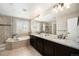 Luxurious bathroom featuring a large vanity, soaking tub, and glass-enclosed shower at 6173 Eldora St, Golden, CO 80403