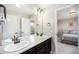 Bathroom featuring a double vanity, granite countertops, and a doorway to a bedroom at 6173 Eldora St, Golden, CO 80403