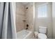 Bathroom highlighting a tiled shower, toilet, and window with blind at 6173 Eldora St, Golden, CO 80403
