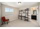 Neutral bedroom featuring a window, shelf, and doorway to the ensuite bath at 6173 Eldora St, Golden, CO 80403