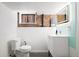 Modern bathroom with illuminated mirror, brick accent wall, and a sleek white vanity at 1430 Monroe St, Denver, CO 80206