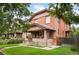 Attractive brick home featuring a quaint covered porch and well-maintained front lawn at 1430 Monroe St, Denver, CO 80206