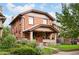 Charming brick two-story home with a covered front porch and mature landscaping at 1430 Monroe St, Denver, CO 80206