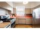 Retro kitchen featuring stainless appliances, orange countertops, and light-filled windows at 1430 Monroe St, Denver, CO 80206