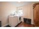Functional laundry room with washer, dryer, brick floors, and textured walls at 1430 Monroe St, Denver, CO 80206