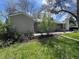 A spacious backyard showcasing green lawn and a stone chimney at 1950 Glen Shiel Dr, Lakewood, CO 80215
