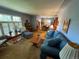 Comfortable living room with a blue sofa, wooden coffee table, and natural light streaming through shuttered windows at 1950 Glen Shiel Dr, Lakewood, CO 80215