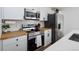 Modern kitchen featuring stainless steel appliances, butcher block countertops and white backsplash at 4793 S Swadley St, Morrison, CO 80465