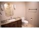Bathroom boasting a granite-topped vanity, decorative mirror, sconces, and modern toilet at 226 Hidden Valley Ln, Castle Rock, CO 80108