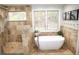 Luxurious bathroom featuring soaking tub, walk-in shower, and travertine tile at 226 Hidden Valley Ln, Castle Rock, CO 80108