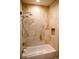 Bathroom showcasing a tub-shower combo with a clear glass enclosure and beige marble tiling at 226 Hidden Valley Ln, Castle Rock, CO 80108
