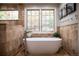 Inviting bathroom showcasing a freestanding tub and a large window with outside views at 226 Hidden Valley Ln, Castle Rock, CO 80108