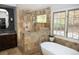 Luxurious bathroom featuring a standalone tub, a shower, and two windows overlooking the yard at 226 Hidden Valley Ln, Castle Rock, CO 80108