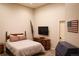 Cozy bedroom featuring a wood-framed bed, matching dresser, wall-mounted television, and patriotic decor at 226 Hidden Valley Ln, Castle Rock, CO 80108