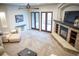 Open-concept living room featuring a stone fireplace, large windows, and neutral decor at 226 Hidden Valley Ln, Castle Rock, CO 80108