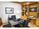 Spacious office boasts custom wood shelving, a gray office desk, and comfortable black leather chairs at 226 Hidden Valley Ln, Castle Rock, CO 80108
