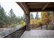 Covered outdoor patio overlooking mature trees with stone columns and iron railings at 226 Hidden Valley Ln, Castle Rock, CO 80108