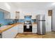 Well-appointed kitchen features stainless steel appliances, ample counter space, and stylish blue backsplash at 9240 W 49Th Ave # 317, Wheat Ridge, CO 80033