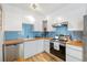 Bright kitchen features white cabinets, wood countertops, stainless steel appliances, and blue backsplash at 9240 W 49Th Ave # 317, Wheat Ridge, CO 80033