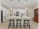 Modern kitchen with white cabinets, stainless steel appliances, and a breakfast bar with three black stools at 4538 Hidden Gulch Rd, Castle Rock, CO 80104