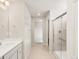 Well-lit bathroom featuring double sinks, tiled flooring, and a glass-enclosed shower for a refreshing experience at 8879 Sedalia St, Commerce City, CO 80022