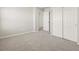 Carpeted bedroom features ample natural light from the windows and a closet with sliding doors at 8879 Sedalia St, Commerce City, CO 80022