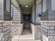 Inviting covered entryway with stone columns and a black front door, creating a welcoming entrance at 8879 Sedalia St, Commerce City, CO 80022