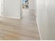 Bright hallway featuring modern light wood-look floors and a view to the deck in the background at 8879 Sedalia St, Commerce City, CO 80022