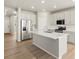 Bright, open kitchen features white cabinets, stainless steel appliances, and a large center island at 8879 Sedalia St, Commerce City, CO 80022