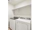 Convenient laundry room equipped with a new washer and dryer, plus a shelf for supplies at 8879 Sedalia St, Commerce City, CO 80022