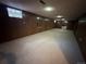 Unfinished basement with wood paneling, carpet, and access to one window at 12831 E Mexico Ave, Aurora, CO 80012