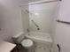 Bathroom featuring a tub/shower combo, a toilet, and patterned vinyl flooring at 12831 E Mexico Ave, Aurora, CO 80012