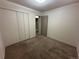 A cozy bedroom includes a closet, neutral walls, carpet, and an entrance to the bathroom at 12831 E Mexico Ave, Aurora, CO 80012