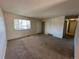 Inviting living room featuring neutral carpet, a bright window, and a view into the hallway at 12831 E Mexico Ave, Aurora, CO 80012