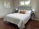 Bright bedroom featuring hardwood floors, a large window, and a cozy bed with stylish decor at 8610 Jolene Dr, Denver, CO 80229