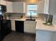 Modern kitchen featuring white cabinets, black appliances, and ample counter space at 8610 Jolene Dr, Denver, CO 80229