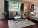 Bright living room with large window, hardwood floors, and view to dining at 8610 Jolene Dr, Denver, CO 80229