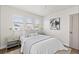 This bedroom boasts neutral tones, three windows, and a stylish abstract painting, creating a serene retreat at 3250 N Clayton St, Denver, CO 80205